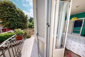 una porta aperta su un balcone con tavolo di Green House Apartment - Como a Como