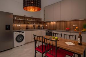 a kitchen with a wooden table with chairs and a washing machine at Luxury Olea Valley Apartment - Nikiti Poolside Gem in Nikiti