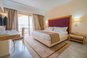 a hotel room with a bed and a balcony at Marhaba Palace in Port El Kantaoui +55 photos