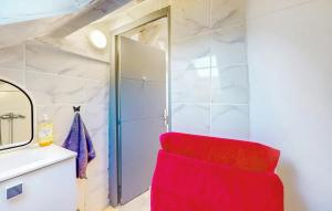 a red chair in a bathroom with a mirror at Charmant appartement avec jardin à Schiltigheim, 30 m² in Schiltigheim +9 photos
