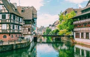 シルティカイムにあるAppartement spacieux à Schiltigheim avec jardinの運河の隣の建物のある都市の川