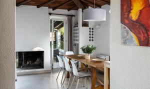 Un comedor con mesa y sillas y chimenea. en Villetta Quattro, en Costa Rei