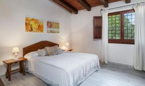 a white bedroom with a bed and a window at Villa Fiori 3 in Is Molas 