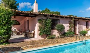 a house with a swimming pool in front of it at Villa Fiori 3 in Is Molas 