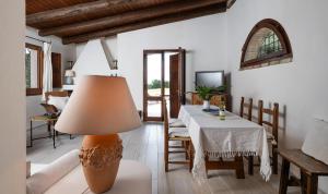 a living room with a table and a lamp at Villa Fiori 3 in Is Molas 