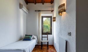 een slaapkamer met een bed, een stoel en een raam bij Villetta 12 in Costa Rei