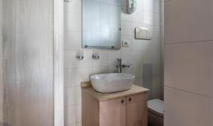 een badkamer met een witte wastafel en een spiegel bij Villetta 12 in Costa Rei +19 foto's