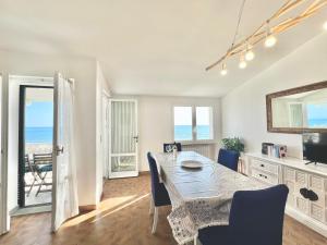 Un comedor con mesa y vista al mar. en Rosanna, terrazza vista mare, 2 camere, clima e 2 posti auto a soli 50 m dal mare! by Alfareal, en Castiglione della Pescaia 15 fotos más