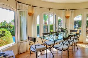 ein Esszimmer mit einem Glastisch und Stühlen in der Unterkunft Villa Narby in Jávea