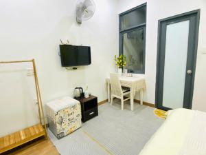 a bedroom with a bed and a table and a tv at Pina Home in Da Nang