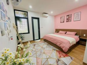 a bedroom with a bed with pink walls at Pina Home in Da Nang