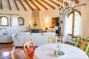 ein Wohnzimmer mit Tisch und Couch in der Unterkunft Villa Narby in Jávea