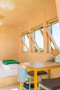 a tiny house with a table and a bed at Hihahut De Vogelaar in Oud-Ade