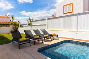eine Terrasse mit Stühlen und einem Swimmingpool in der Unterkunft Villa Girassol - By Dalma Portuguesa in Olhos de Água