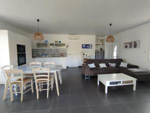 a living room with a couch and a table and chairs at VILLA climatisée tout confort Proche mer et montagne 3 chbres in Campodiloro