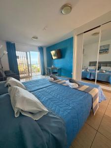 ein blaues Schlafzimmer mit einem großen Bett und einem großen Fenster in der Unterkunft Blue Ocean in Costa Del Silencio + 8 Fotos