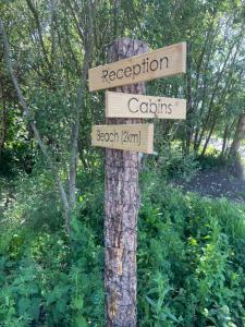 a sign on a tree with direction signs on it at North Shore Sligo - Cabins in Grange