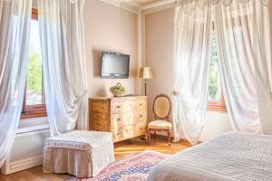 1 dormitorio con 1 cama, vestidor y TV en Villa Sestilia Guest House, en Montaione