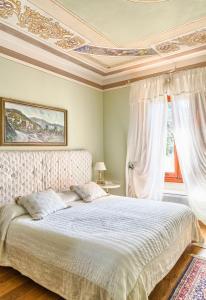 1 Schlafzimmer mit einem weißen Bett und einer Kassettendecke in der Unterkunft Villa Sestilia Guest House in Montaione