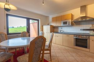 cocina con mesa, mesa y sillas en Landgasthaus Backhof-Helmle, en Breitnau