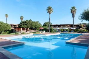 ポルト・ロトンドにあるApp Porto Rotondoのヤシの木が背景に広いスイミングプール