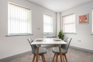 a white dining room with a white table and chairs at Spacious & Bright 1 Bed Flat in Central Doncaster in Doncaster