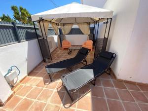 un patio con 2 sillas y una mesa con sombrilla en Vila Alegre, en Fuseta