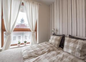a bedroom with a bed and a large window at Apartament z widokiem na dworek in Gdańsk