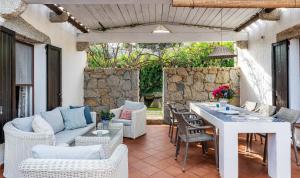 eine Terrasse mit einem Tisch, Stühlen und einer Steinmauer in der Unterkunft Casa 2 in Castiadas