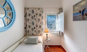 ein kleines Schlafzimmer mit einem Bett und einem Fenster in der Unterkunft Casa 2 in Castiadas