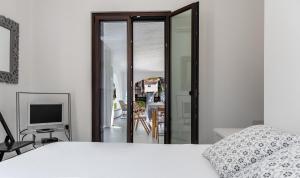 een slaapkamer met een wit bed en een televisie bij Villa Lantana in Pula