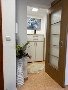a kitchen with a vase with flowers in it at City Center Apartment in Pristina +1 photo