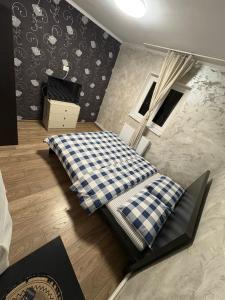 a bedroom with a bed with a checkered blanket at Safir Luxury imperial 666 in Bucharest