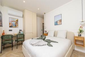 a bedroom with a white bed and a desk at SUITE DELUXE - MONACO - Vue Jardin in Beausoleil