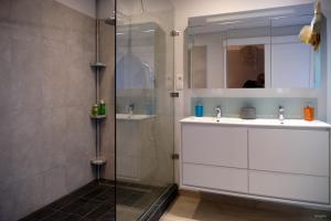 a bathroom with two sinks and a glass shower at Le Gouzou in Tamarin +6 photos