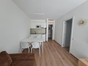 a living room and kitchen with a table and chairs at Apartamentos Alisios con terraza y piscina in Corralejo