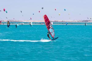 a person is windsurfing in the ocean on the water at Palm Royale Resort - Soma Bay in Hurghada