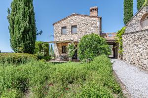- une vue extérieure sur une maison en pierre avec des arbres dans l'établissement Affitti Brevi Siena - Le Rose Appartamento in Toscana con piscina da sogno, à Asciano