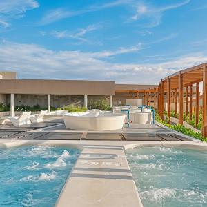 ムイネーにあるMandala Chambay - Ruby Boutique Resortの椅子と建物のあるプール