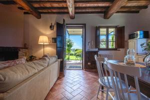 un salon avec un canapé et une table dans l'établissement Affitti Brevi Siena - Le Rose Appartamento in Toscana con piscina da sogno, à Asciano