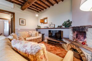 un salon avec un canapé et une cheminée dans l'établissement Affitti Brevi Siena - Le Rose Appartamento in Toscana con piscina da sogno, à Asciano