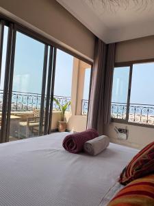 a bedroom with a bed with a view of a balcony at SurfAppart Morocco in Tamraght Ouzdar