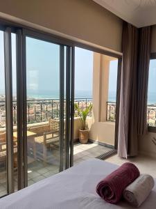 a bedroom with a bed and a view of the ocean at SurfAppart Morocco in Tamraght Ouzdar