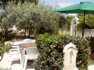 un jardín con mesa, sillas y sombrilla en Monolocale Birgi, en Birgi Vecchi