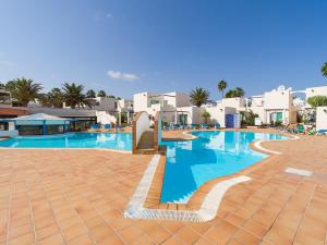 a large swimming pool in a resort with white buildings at Alisios Easy Stay in Corralejo