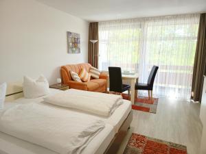 a bedroom with a bed and a couch and a table at Appartementhaus Nürnberg in Bad Füssing