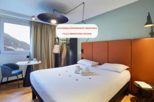 Una habitación de hotel con una cama con dos toallas encima. en Ibis Sallanches Porte du MontBlanc, en Sallanches