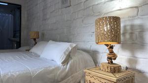 a bedroom with a bed and a lamp on a table at Hostería Chez DidierM in Iruya