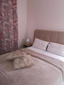 a bed with a furry pillow on top of it at Little gem in Rafina