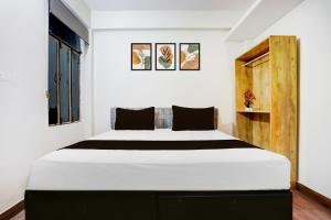 Hotel O George Town في Colonelganj: غرفة نوم بها سرير كبير في الغرفة